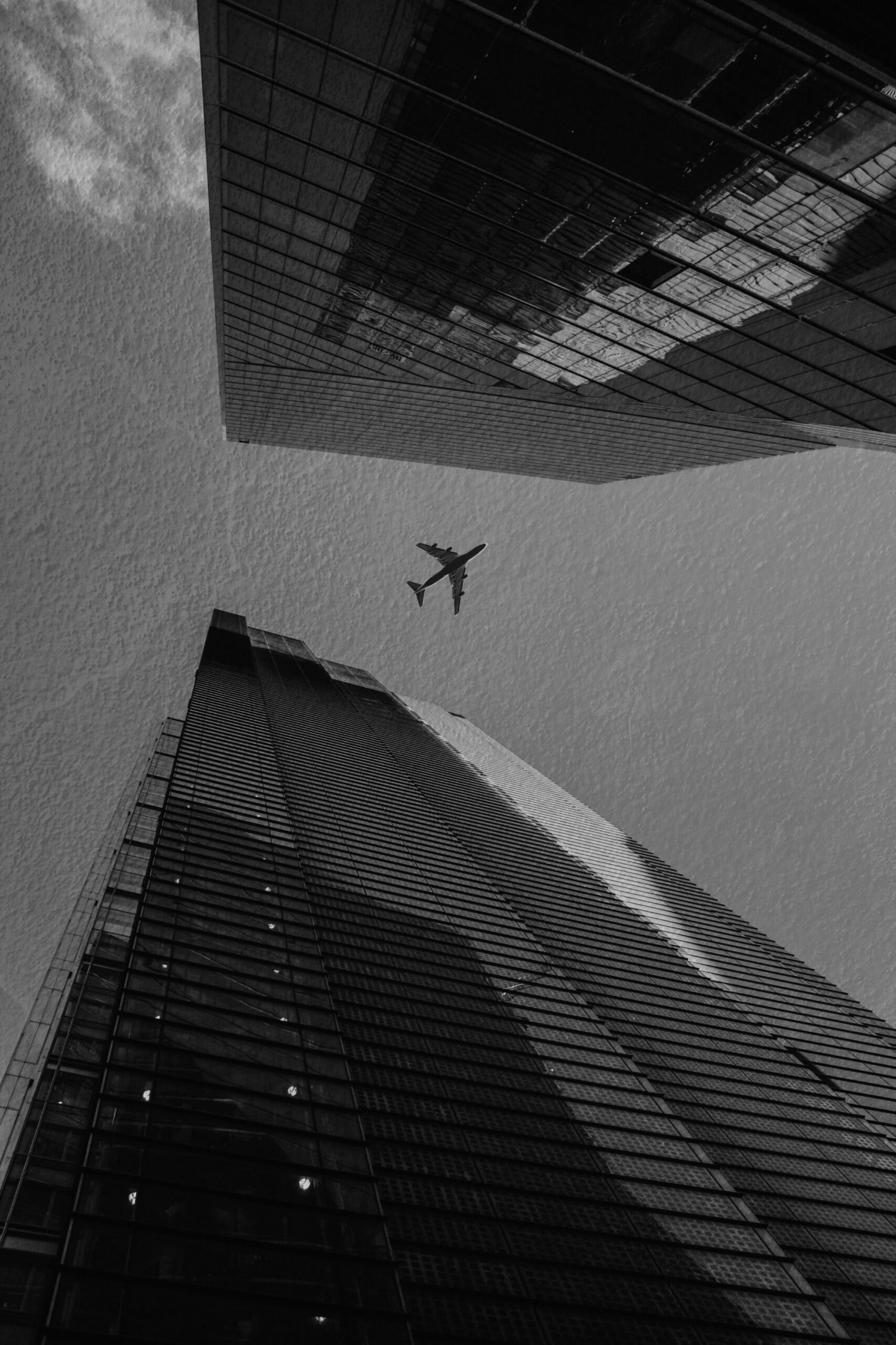 Airplane flying above two skyscrapers